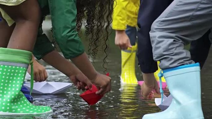 孩子们把纸船放在水坑里