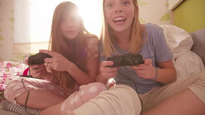 女孩们一起在卧室里玩电脑游戏