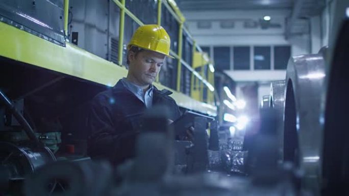 安全帽技术人员在工业环境中使用平板电脑。