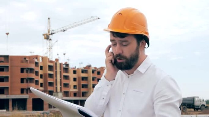 建筑师在建筑工地上用手机聊天