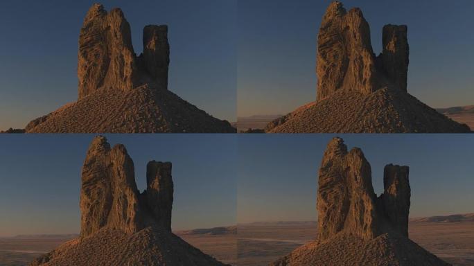 空中: 日出时在火山沙漠中的岩石野猪Tusk地标上飞行