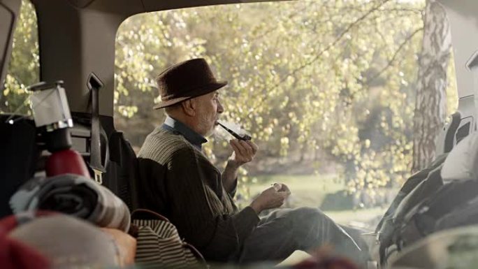 坐在车后的老人抽烟斗