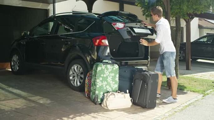 慢动作: 穿白衬衫的人在卸下行李后关闭了汽车后备箱