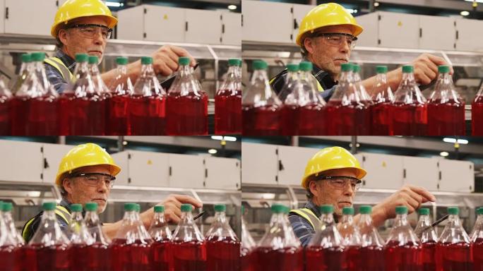 工人在生产线上检查果汁瓶