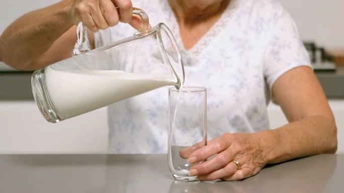 女人在厨房里倒一杯牛奶