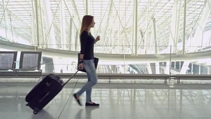 带着行李走过机场航站楼的女性旅客