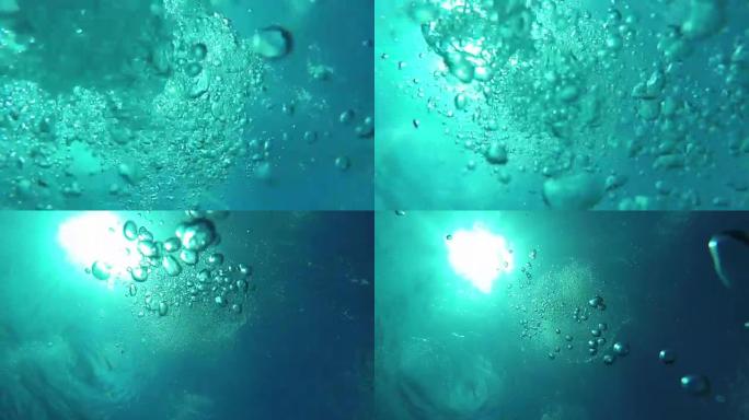 水下宏观: 许多大气泡上升到光滑的海洋表面