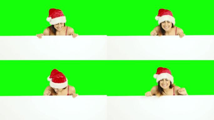 穿着圣诞老人帽子的美女黑发女人展示白色海报