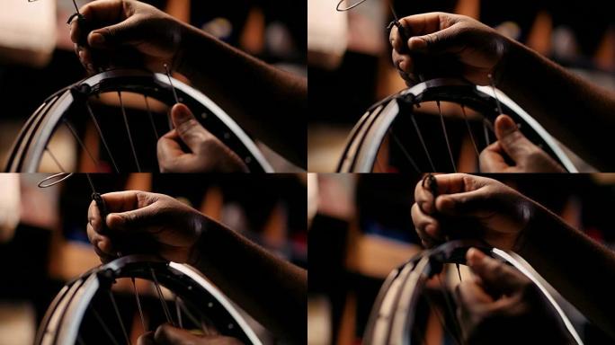 工匠的手修理自行车车轮上的辐条