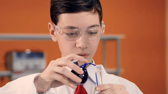 科学课上的小男孩在试管中混合液体。