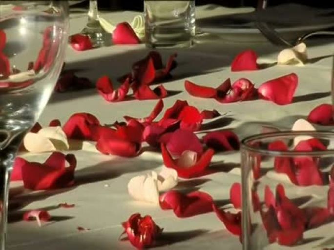 桌上的红花花瓣和玻璃杯（宽屏16:9）