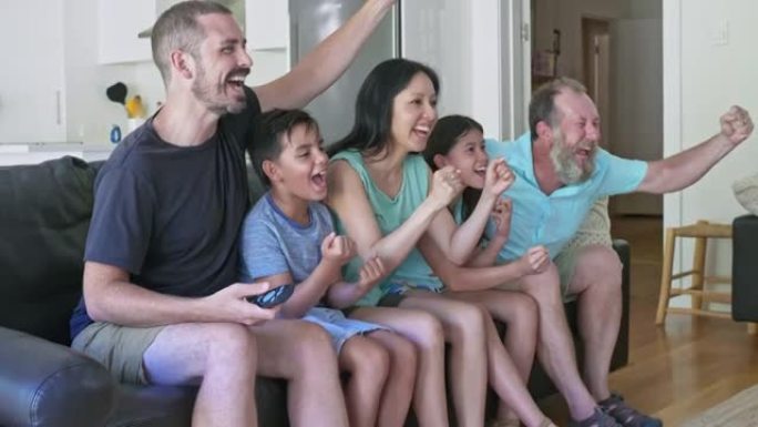 家庭庆祝他们的团队观看电视得分的慢动作视频