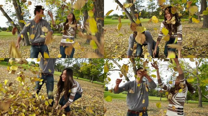 男人和女人在秋天扔树叶玩得很开心