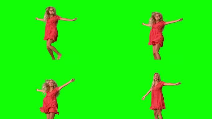 迷人的金发女郎在绿色屏幕上跳跃
