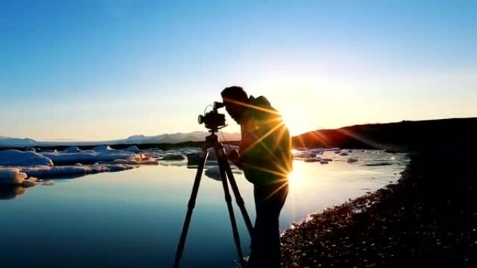 摄影师在日出时拍摄冰川泻湖中的冰山照片。约图尔萨隆河口