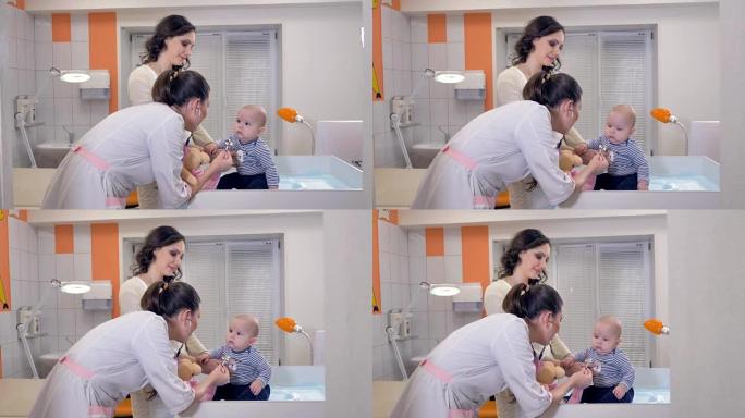 医生在诊所的治疗台上玩婴儿。