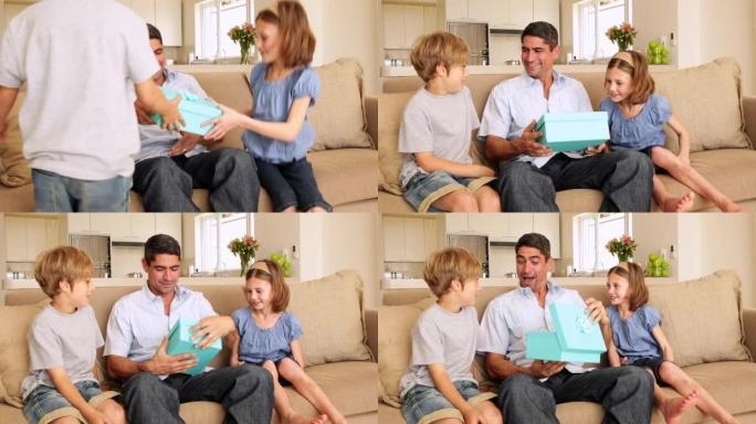 可爱的孩子在沙发上给父亲礼物