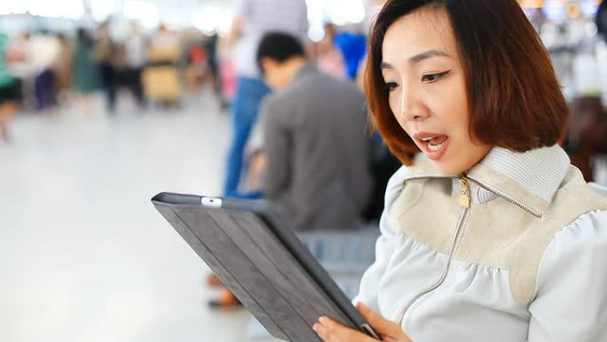 高清：亚洲女性通过平板电脑聊天，情绪激动。