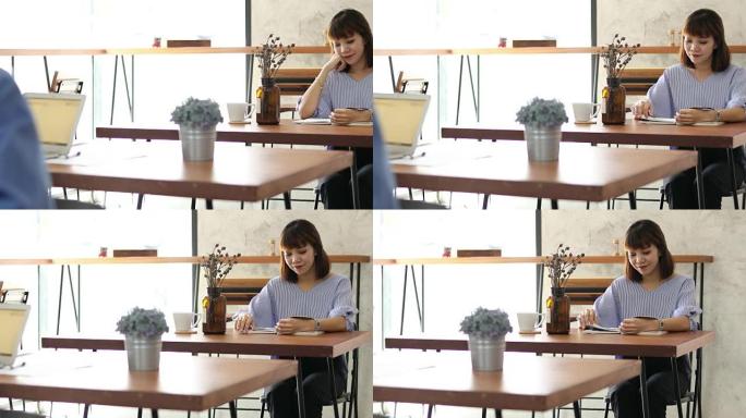 美丽的年轻学生女孩在咖啡馆看书