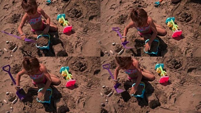 小女孩在海滩上玩玩具
