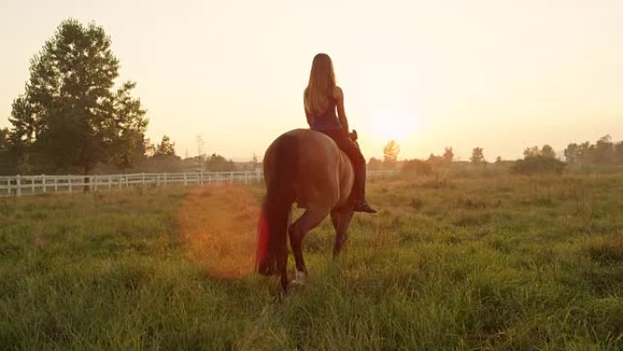 慢动作: 漂亮的金发微笑女孩光着背朝着夕阳骑行