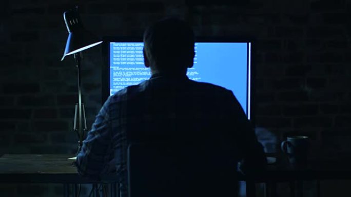年轻的程序员晚上坐在显示器前，正在开发代码。
