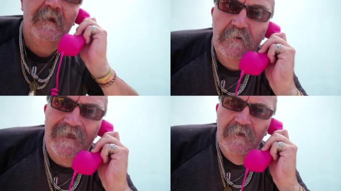 有趣的愤怒的老人拿着粉红色的手机