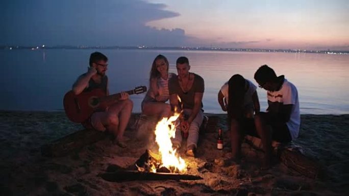 年轻人坐在海滩上着火