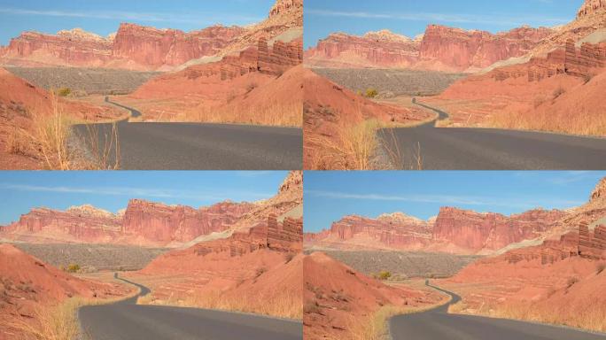 空旷的道路过去侵蚀的山丘和台地山在红色岩石犹他州沙漠