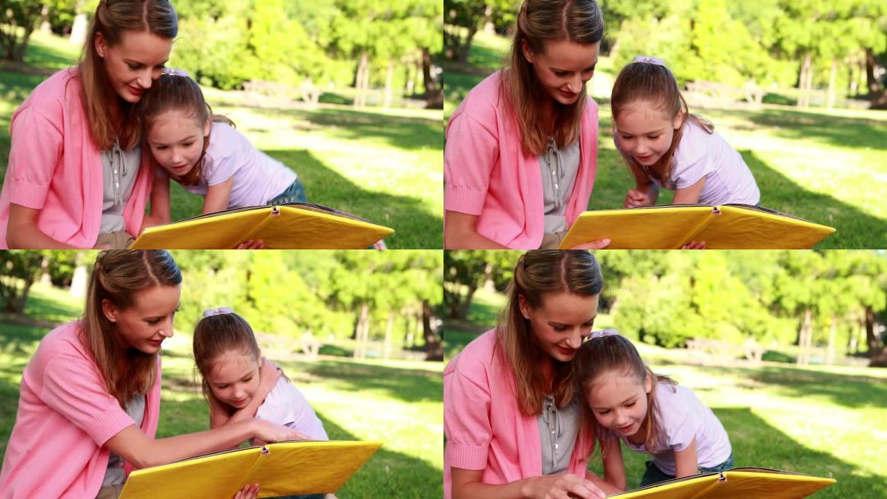 小女孩和她的母亲在公园里读故事书
