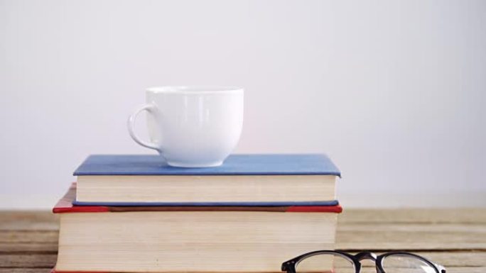 木桌4k上的书籍、咖啡杯和眼镜