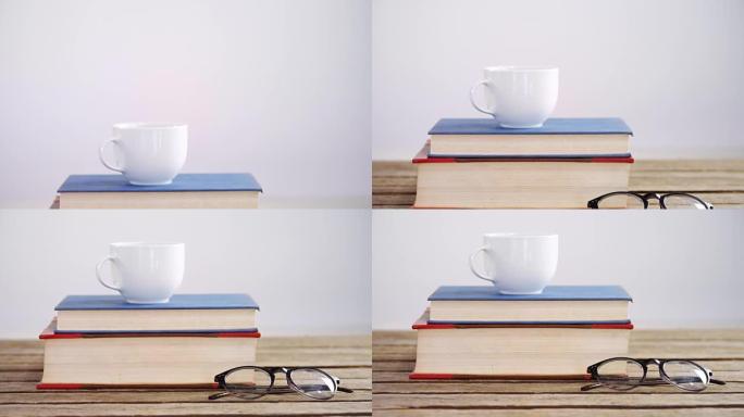木桌4k上的书籍、咖啡杯和眼镜