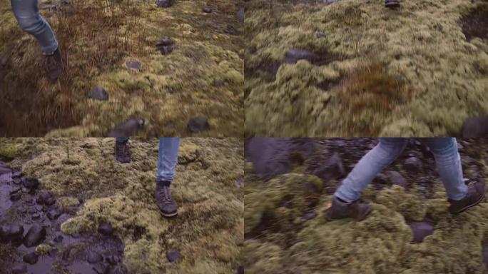 穿靴子的女性脚的特写镜头。年轻女子带着苔藓穿过沼泽，独自探索大自然