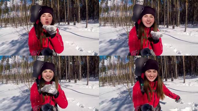 年轻快乐的旅游女孩从手掌吹雪。