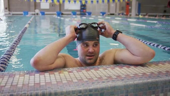 男性游泳运动员戴上护目镜