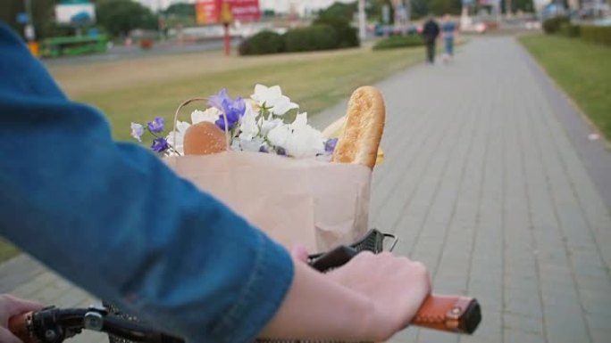 女人在街上行走时，把手放在自行车车把上，篮子里放着鲜花和面包，缓慢的mo，steadicam射击