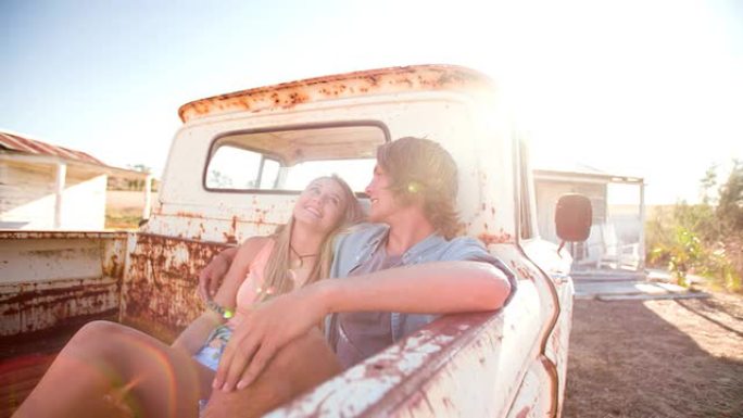 青少年夫妇亲切地坐在一辆老式卡车上
