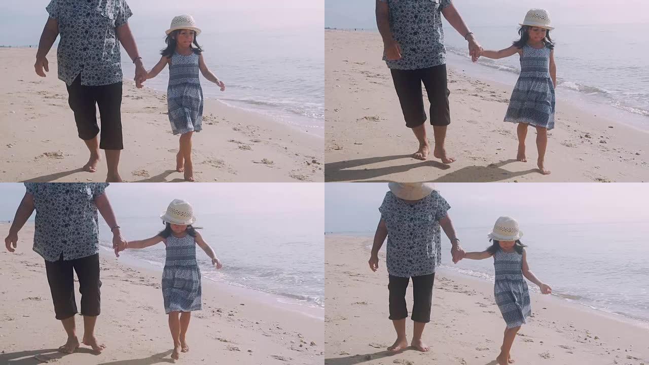 祖母和孙女手牵着手沿着海滩散步