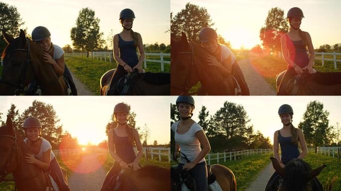 慢动作: 两个开朗的年轻女孩在神奇的日落中享受骑马的乐趣