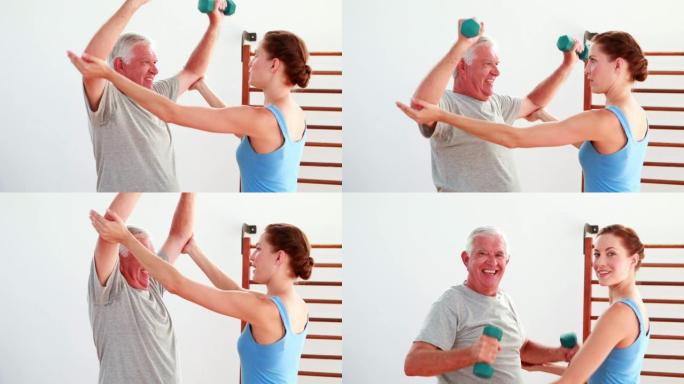 年长的男子在物理治疗师的帮助下举起手的重量