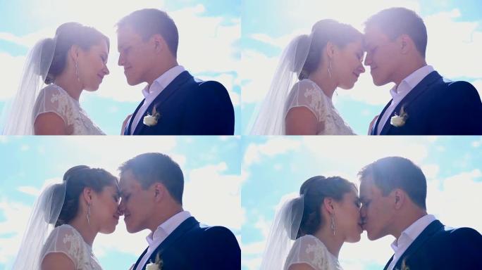 恋爱中的美丽年轻夫妇刚刚结婚在阳光下亲吻