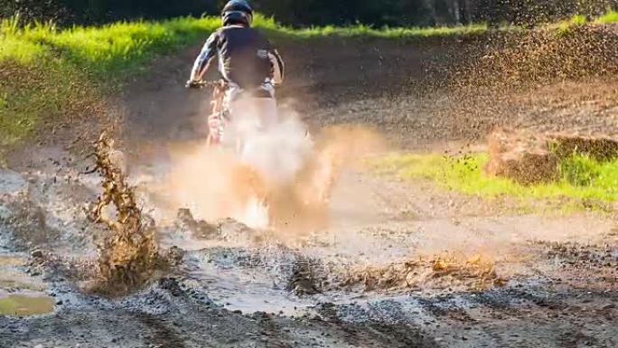 越野摩托车骑手在泥泞的泥坑中行驶
