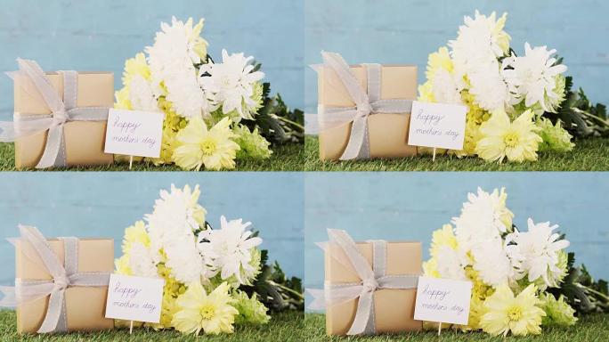 礼品盒，母亲节快乐标签和草地上的鲜花