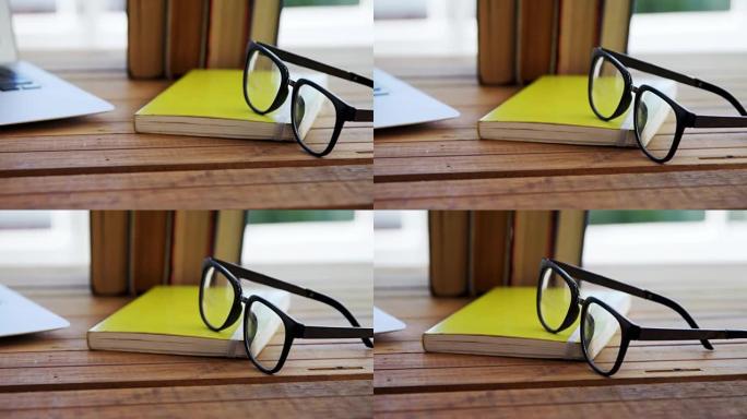 笔记本电脑、书籍和木制桌子上的眼镜4k