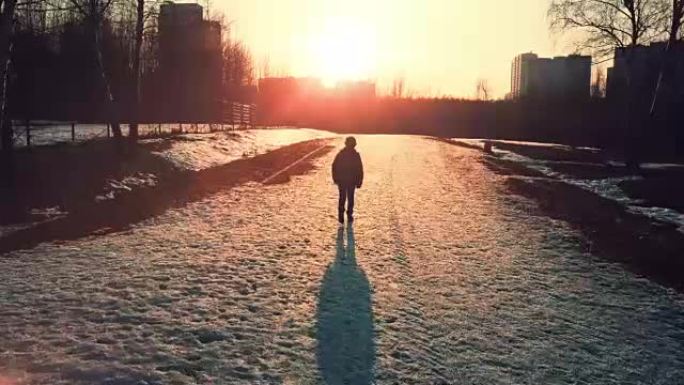 日落时一个男孩独自在公园散步