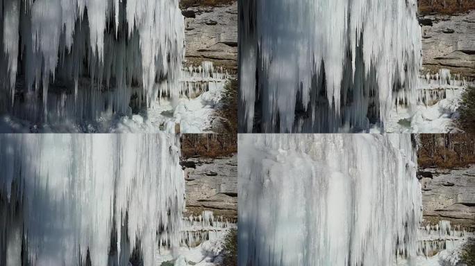 空中: 在冬季山崖上飞起令人惊叹的冰冻瀑布冰柱