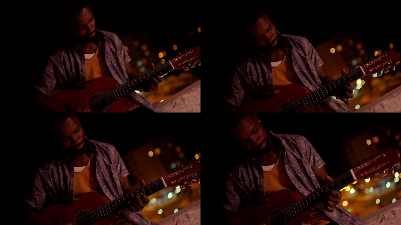 年轻的潮人非裔美国人晚上弹吉他
