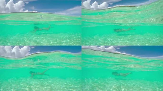 年轻女子在热带岛屿的梦幻般的海洋中水下游泳