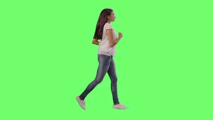 穿着休闲服的年轻女孩在模拟绿屏上奔跑。
