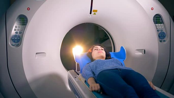 一名年轻女子在ct扫描前脸朝上躺着。